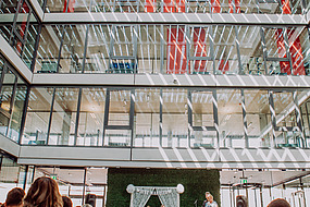 Bild der Event-Location Innenansicht mit Menschen auf Stühlen